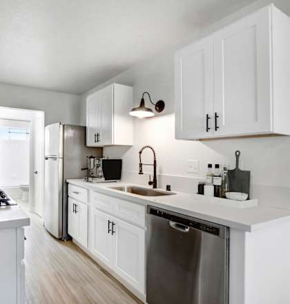a kitchen with white cabinets and stainless steel appliances