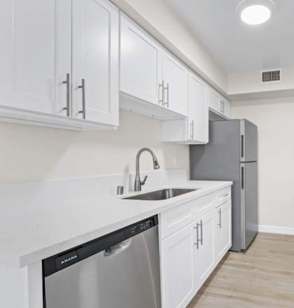 a kitchen with white cabinets and stainless steel appliances