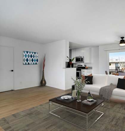 a living room with a white couch and a glass coffee table