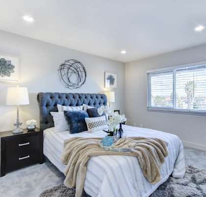 a bedroom with a large bed next to a window