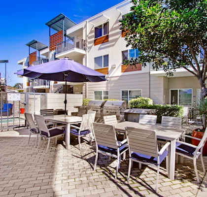a patio with tables and chairs and umbrellas