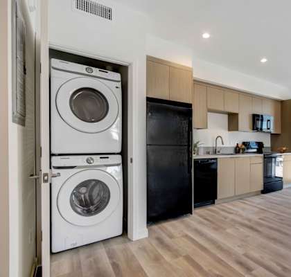 a kitchen and living room with a washer and dryer combo