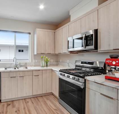 a kitchen with light wood cabinets and stainless steel appliances