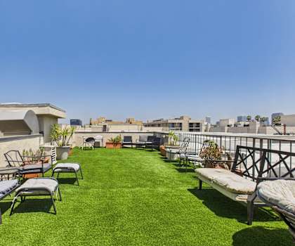 A patio with a lawn and chairs.