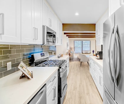 a white kitchen with stainless steel appliances and white cabinets
