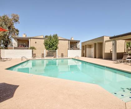 A swimming pool in a backyard with a house in the background.