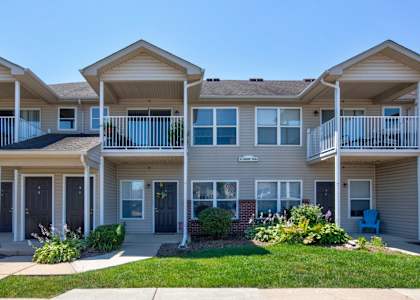 A row of houses with balconies and front yards.