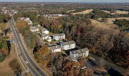 A road with cars on it and apartment buildings.