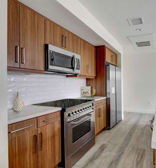 a kitchen with wooden cabinets and white countertops