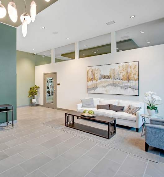 a lobby with a green wall and a couch and a table