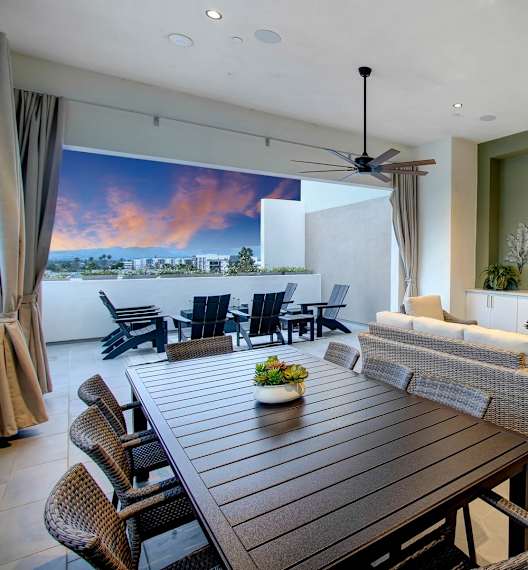 a large living room with a wooden table and chairs