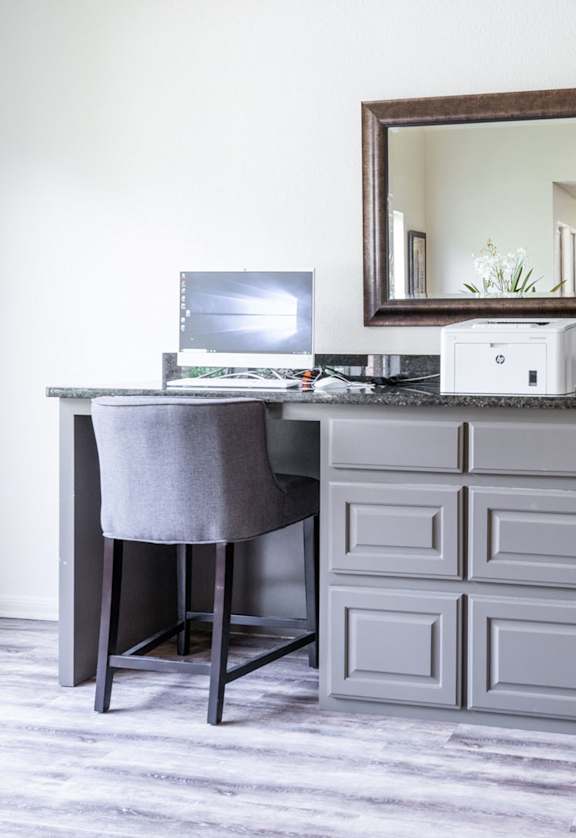 a desk with two chairs in a room with a mirror and a computer at Summit Ridge Apartments, Temple, TX, 76502