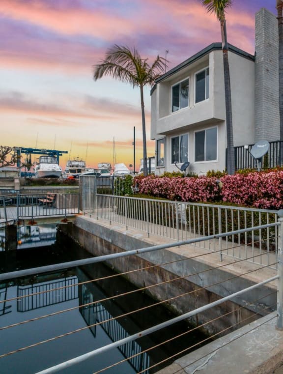 a house overlooking a body of water with a sunset in the background