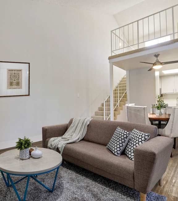 a living room with a spiral staircase and a couch and a table at Meridian Apartments, Los Angeles, CA