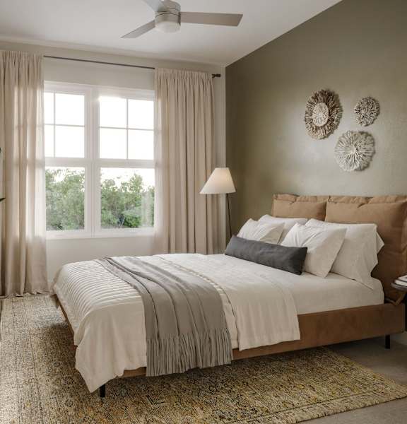 A bedroom with a large bed and a ceiling fan.