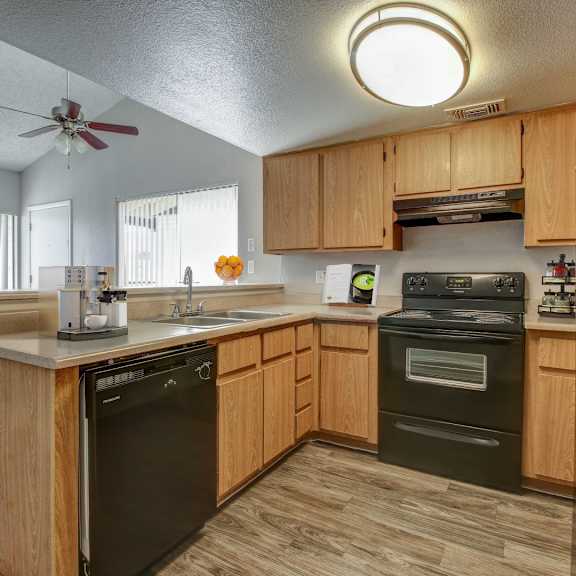 A kitchen with wooden cabinets and black appliances.