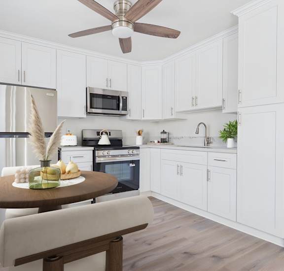 A kitchen with white cabinets and a wooden table.