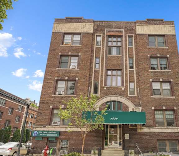 a brick building with a green awning in front of it