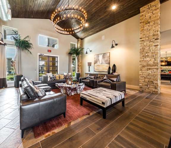 a living room filled with furniture and a large chandelier at Legacy Creekside Apartments, San Antonio, TX