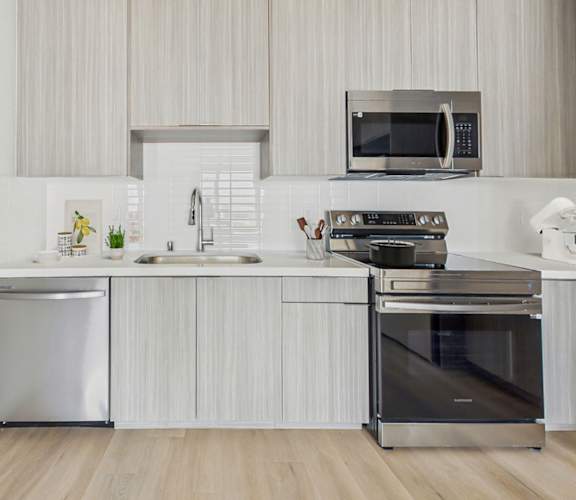 A modern kitchen with a stainless steel oven and microwave.