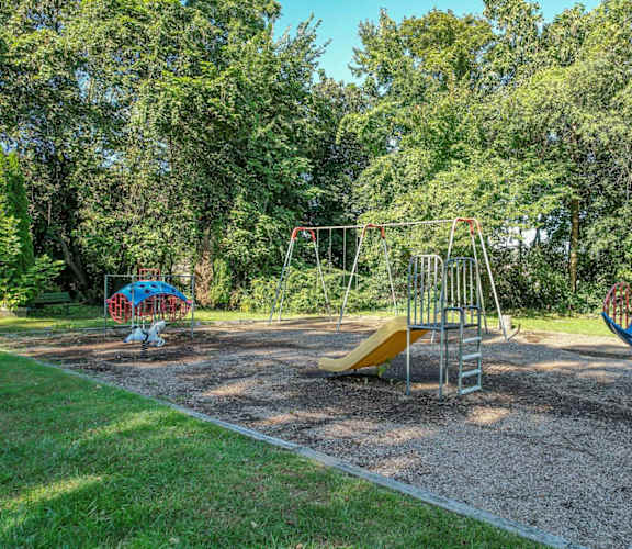 A playground with a yellow slide and a blue slide.