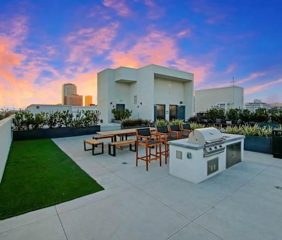 a patio with a grill and a city skyline in the background