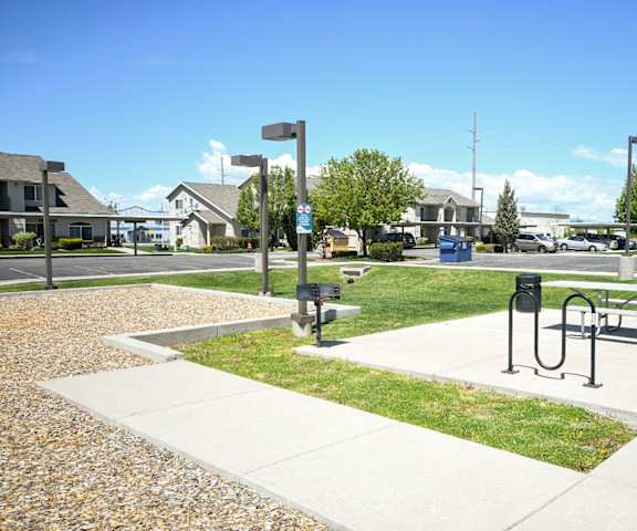 a park with a bench and a picnic table on the sidewalk