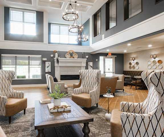 a large living room with chairs and a fireplace at Haven at Congaree Pointe 55+ Apartments, Columbia, 29209