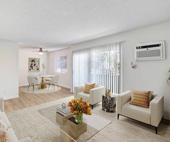 A living room with a white couch, a coffee table, and a dining table.