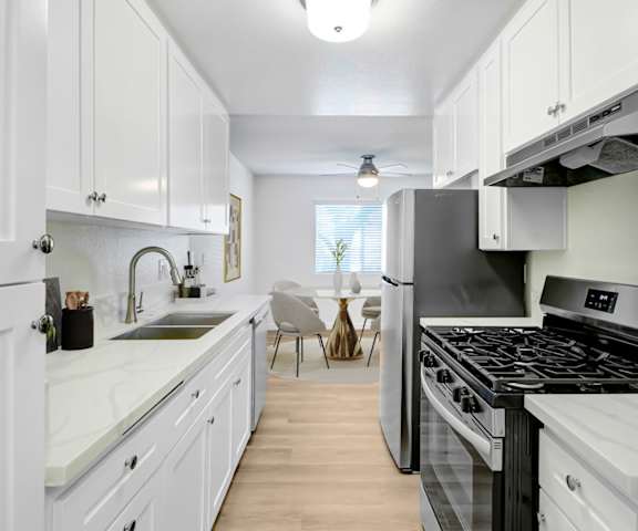 A kitchen with white cabinets and a black stove top oven.