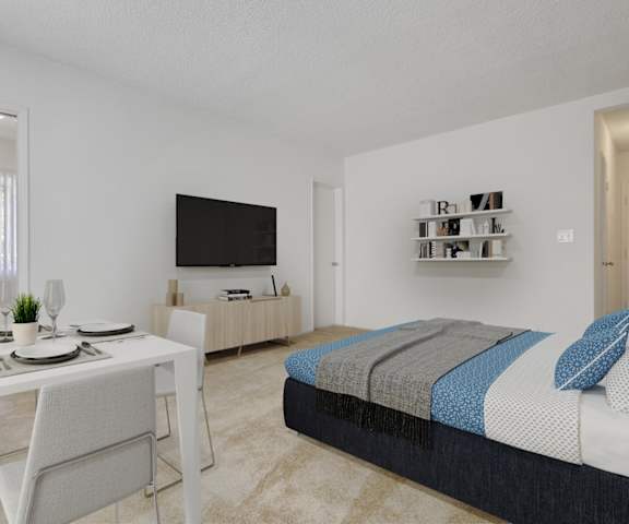 a bedroom with a bed and a desk and a television