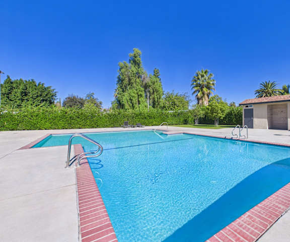 A swimming pool with a red border and a clear blue sky in the background.