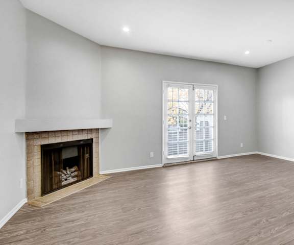 a living room with a fireplace and a door to a patio