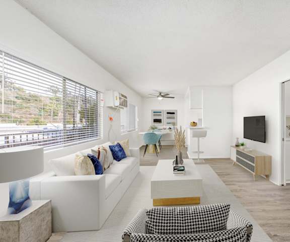 a living room with white furniture and a large window