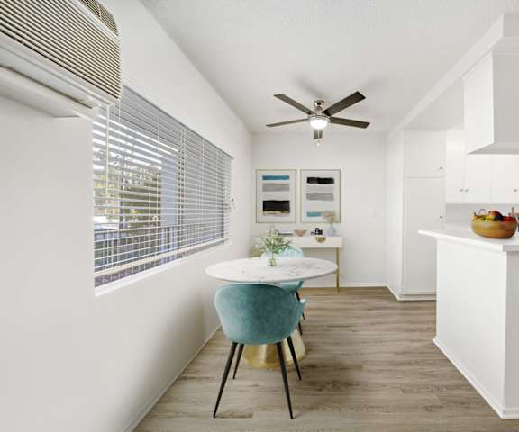 a dining room with a small table and a ceiling fan