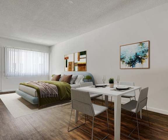 an open living room and dining room with a bed and a table and chairs