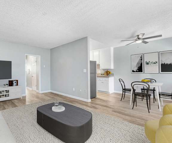 A living room with a white couch and a grey ottoman.