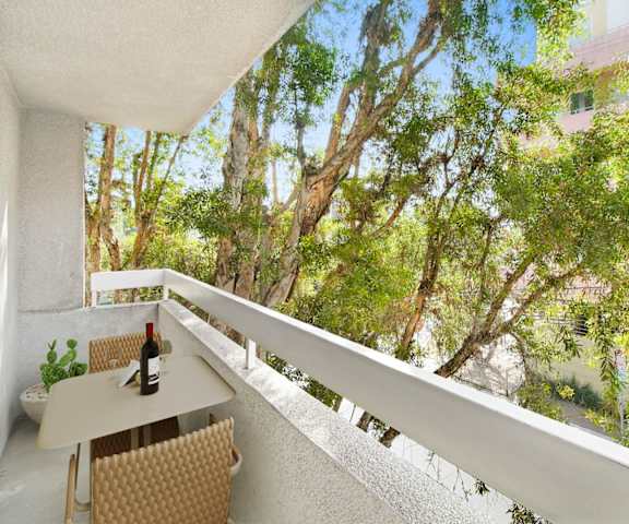 a balcony with a table and a bottle of wine on it