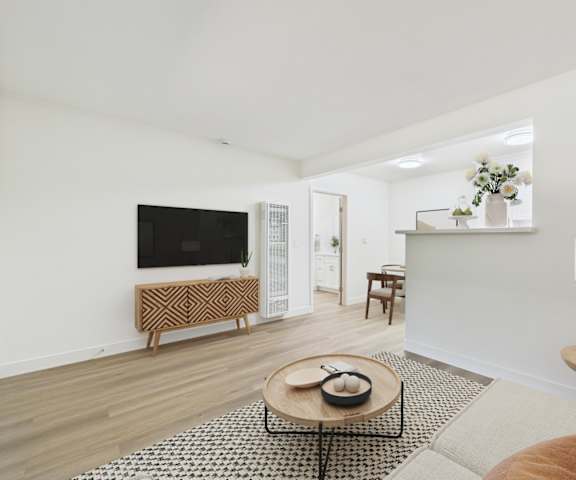 A living room with a television, a bench, a coffee table, and a lamp.