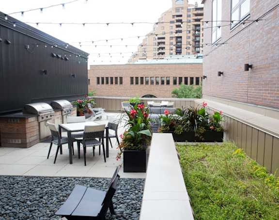 A patio with a table and chairs is surrounded by a brick wall. at The M on Hennepin, Minneapolis, Minnesota