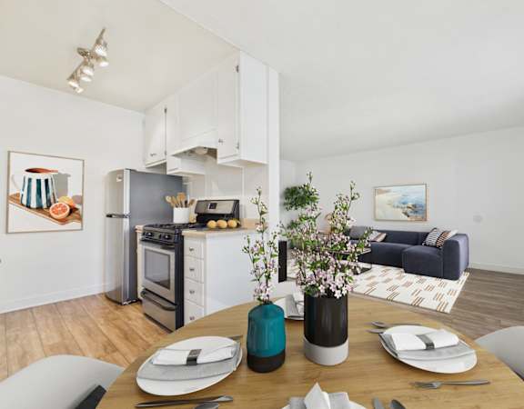 A modern kitchen with a dining table set for two.