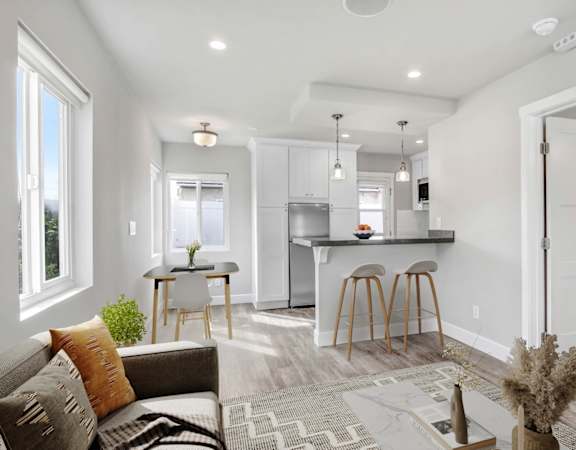a living room with a kitchen with a bar and a couch