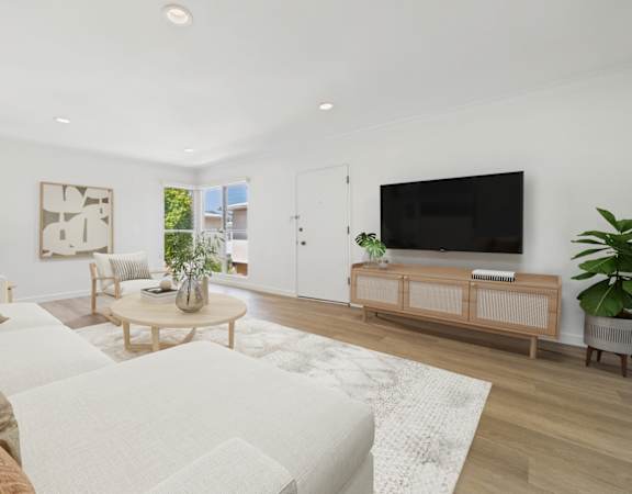A living room with a white couch and a wooden coffee table.