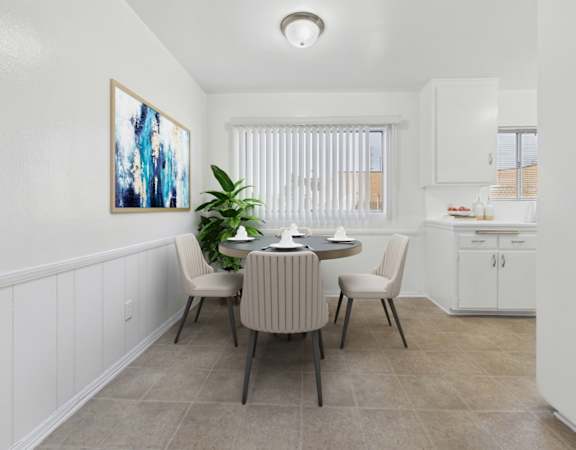 A dining room with a table set for two and a painting on the wall.