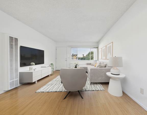A modern living room with a grey chair and a white side table.