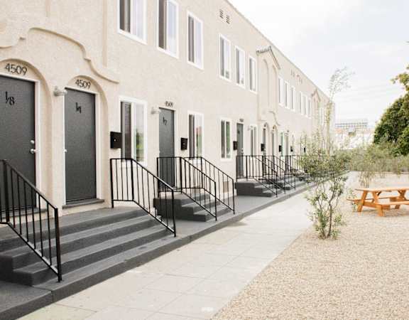 the outside of a building with a picnic table and benches