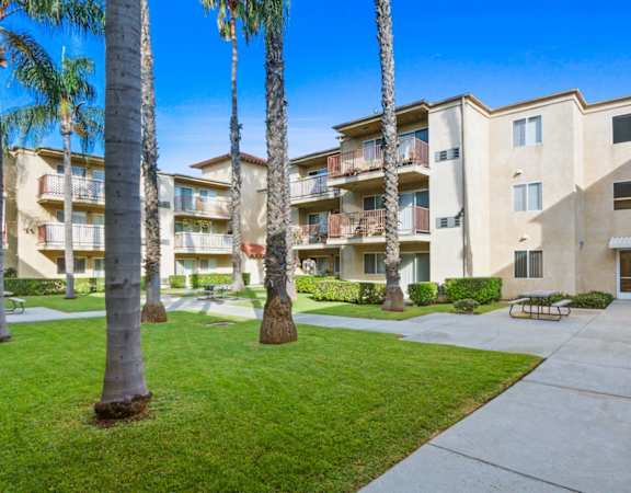 an apartment building with a courtyard and palm trees
