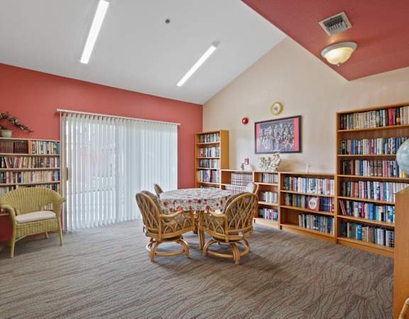 a library with a table and chairs and shelves of books