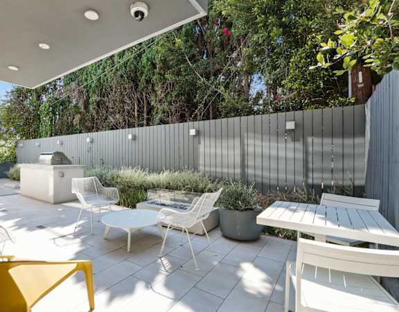 a patio with a table and chairs and a privacy fence