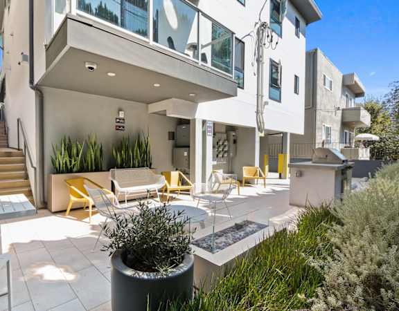 a patio with tables and chairs and a building with stairs
